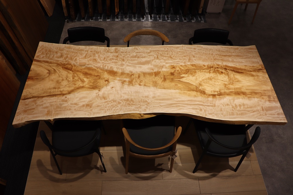 名古屋店のトチ一枚板 テーブル　中央に浮かび上がる、力強い木の流れ